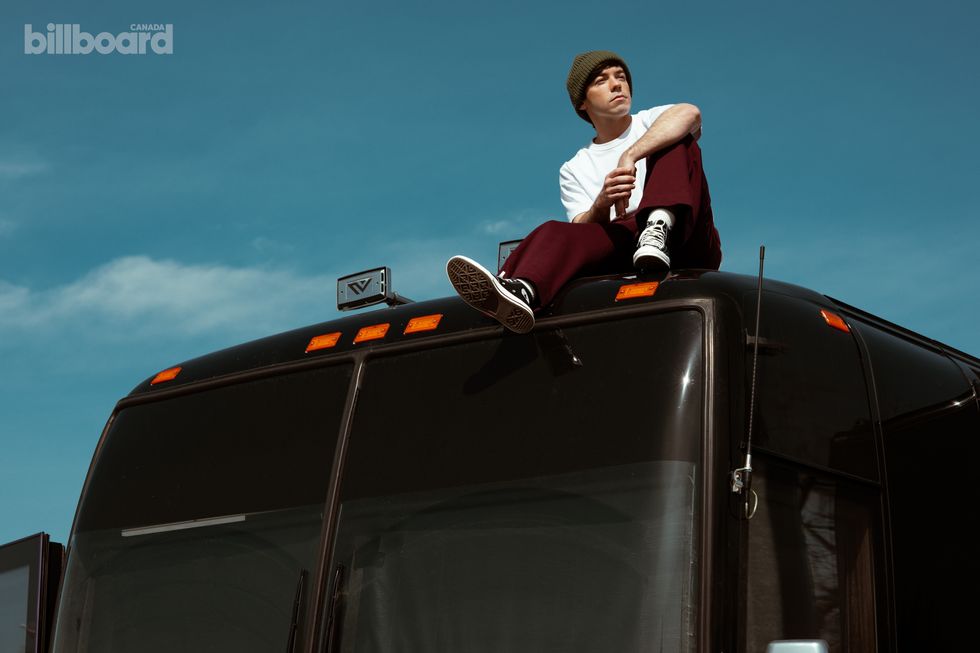 Connor Price photographed by Lane Dorsey on his tour bus in Toronto on Apr. 2, 2025. Styling by Lilli Wickham and style coordinating by Liam Colbourne. Purple Hearts Supply pants and Converse shoes.