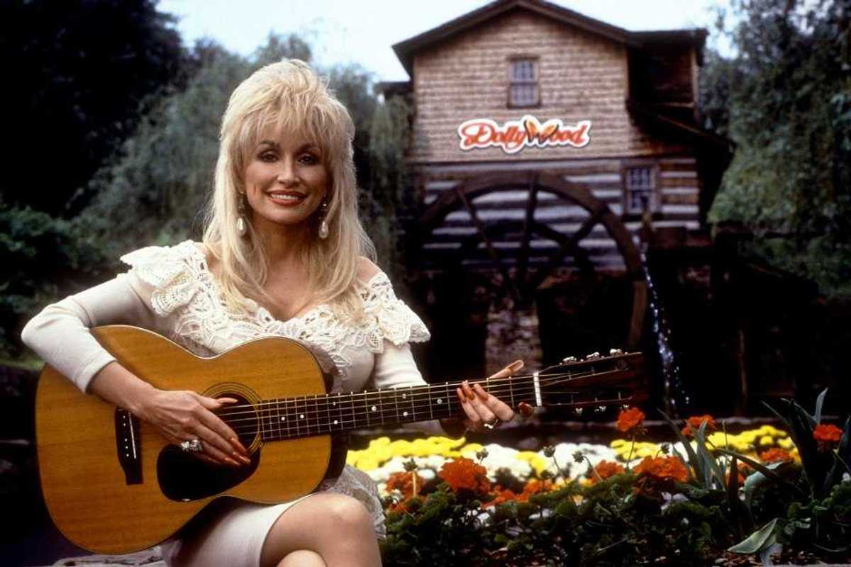 Dolly Parton poses for a portrait with her guitar at Dollywood circa 1993 in Pigeon Forge, Tennessee.