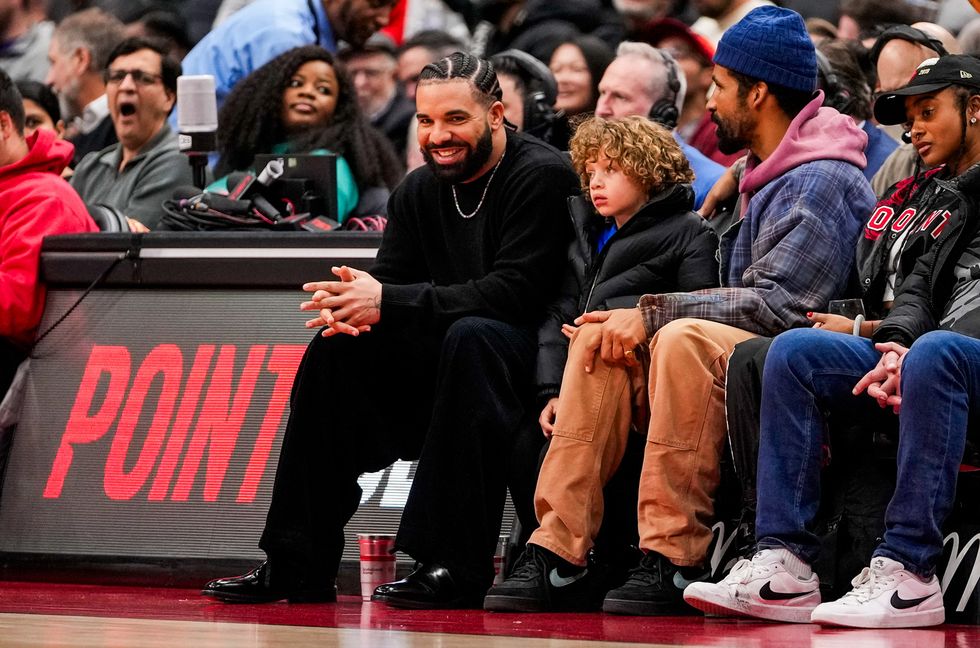 Drake and Adonis watch as the Toronto Raptors host the Phoenix Suns during NBA action at the Scotiabank Arena on Nov. 29, 2023 in Toronto.