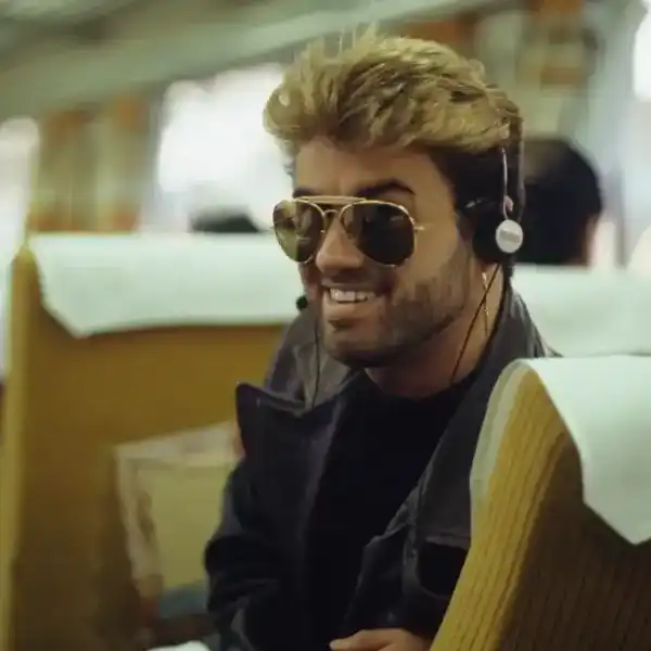 George Michael pictured listening to a Walkman on a bullet train during the Japanese leg of his Faith World Tour in February 1988.