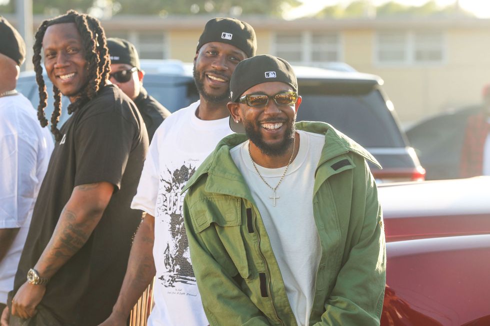 Kendrick Lamar smiles alongside Jay Rock, center, in between filming for the the music video for "Not Like Us" at Nickerson Gardens on June 22, 2024 in Watts, Calif.