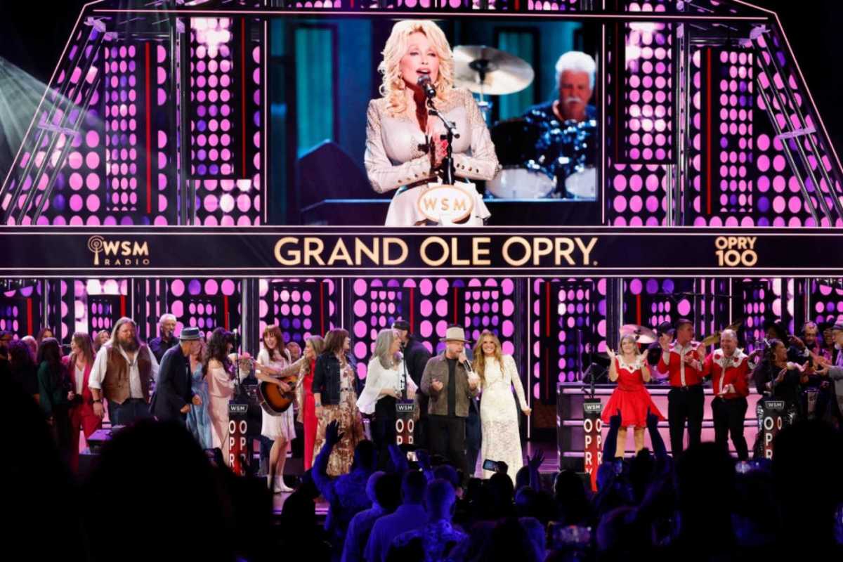 Molly Tuttle, Kathy Mattea, Jelly Roll and Carly Pearce perform onstage as Dolly Parton is seen in a video during the finale of the show Opry 100 - The Opry Remembers Dolly Parton at the Grand Ole Opry House on August 29, 2026 in Nashville.