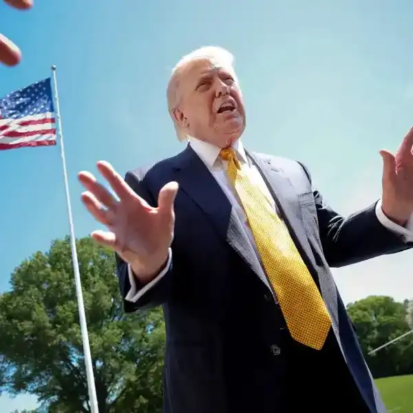 President Donald Trump speaks in front of the American flag to the press as he departs the White House on May 12, 2026, in Washington, D.C.