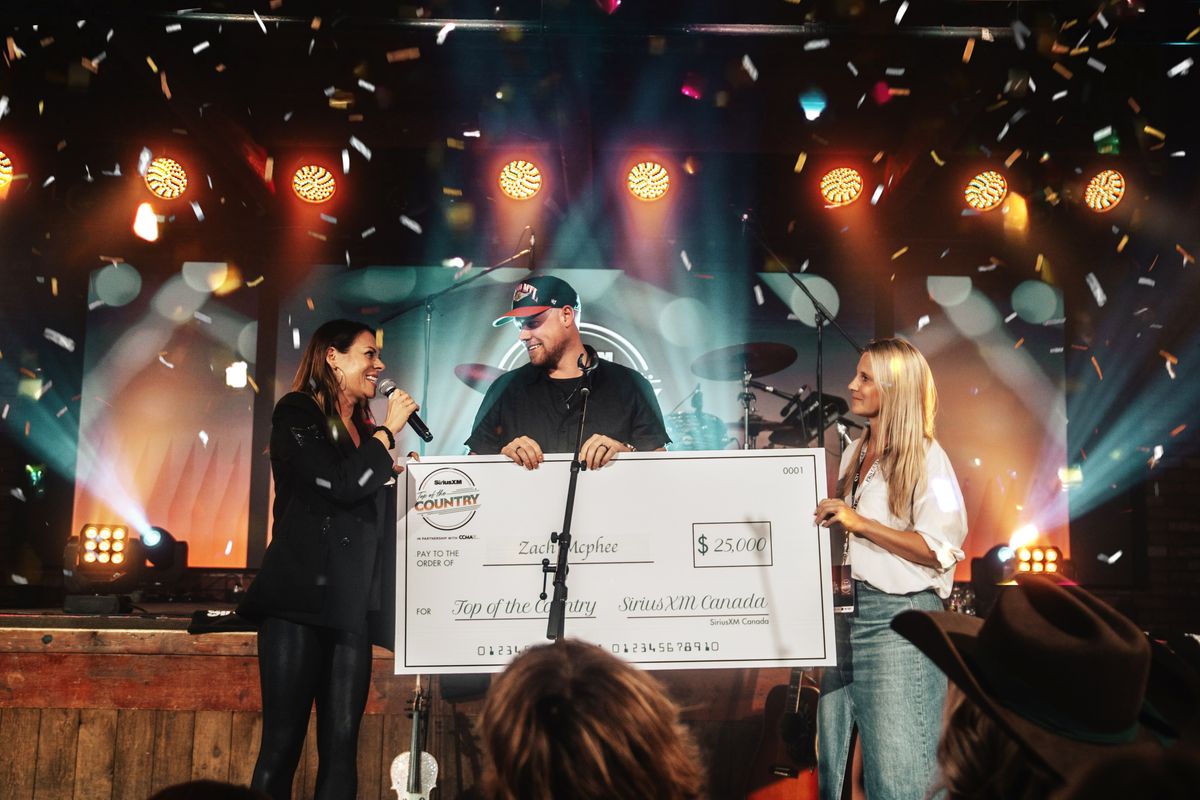 Zach McPhee receives the cheque for $25,000 for SiriusXM's Top of the Country 2024 in Edmonton.